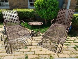 Pair of cast aluminum chaise lounges, with cocktail table, at the ready.