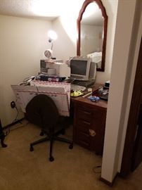 Desk, office supplies, old computer, mirror.