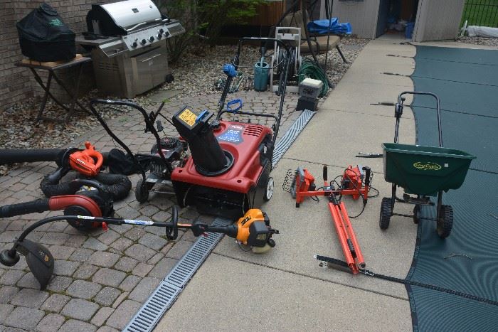 Outdoor equipment. Newer Toro snowblower, Black and Decker electric blower/leaf vacuum, Homelite gas blower, gas weed wacker, gas edger with extra new blades, utility light and lawn fertilizer spreader.