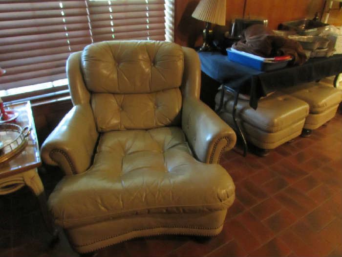 One of a pair leather chairs with ottoman