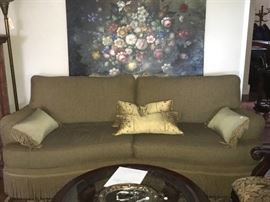 Another view of one of the fringe sofa's along with a view of a beautiful large painting on the wall. 