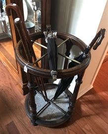 Antique umbrella stand with several antique and vintage umbrellas. 