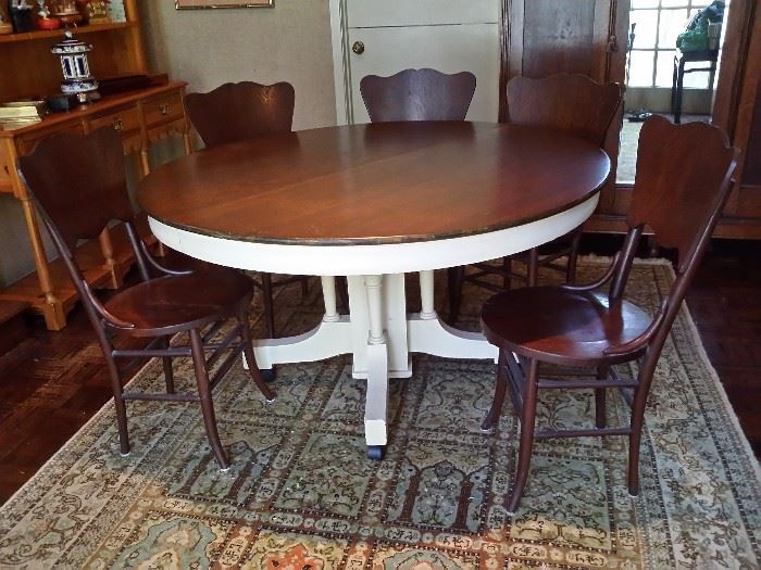 Antique round oak table with a painted base and 5 antique oak chairs.