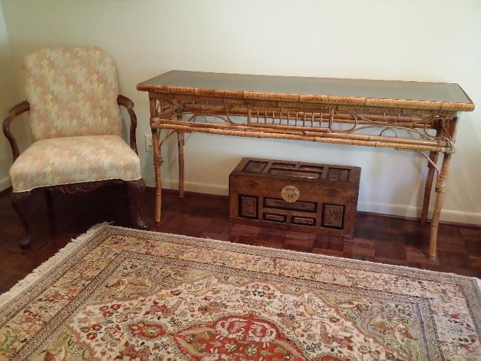 Bamboo table, oriental trunk, upholstered chair, wool rug