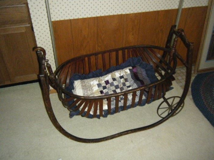 EARLY ANTIQUE CRADLE WITH CURVED SLATS. ALSO ORIGINAL CAST IRON SWING AND WHEELS