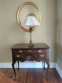 Kittinger Furniture Co. mahogany lowboy with lamp and oval gilt decorated mirror