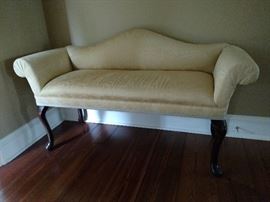 Small camel back settee with scrolled arms and mahogany legs