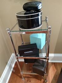 Chanel boxes on a glass and brass shelf