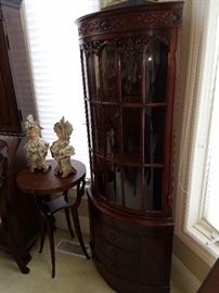 One of a pair of curved mahogany corner cabinets, beside one of a pair of swan-leg stands/tables