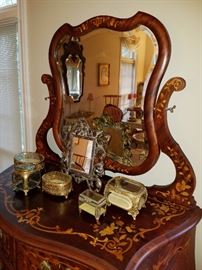 Showing the top with the incredibly inlay.  Displayed are beveled glass jewelry boxes and a cast frame mirror