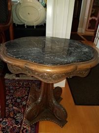 Carved low table with black marble inset