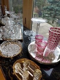 Display of cut glass, including cranberry cut-to-clear vase and two tumblers