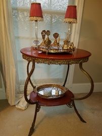 Gilt metal and wood oval table displaying filigree dresser bottles