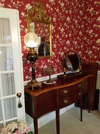 Ethan Allen sideboard (similar to the one we sold out of this spot in the last sale).  It displays an electrified banquet lamp (Bradley & Hubbard), an oval mirror on stand, and more