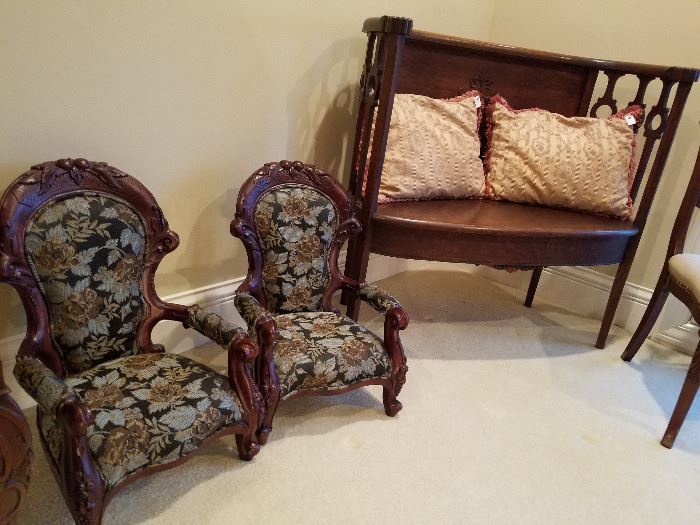 Child or doll size arm chairs next to an oval settee
