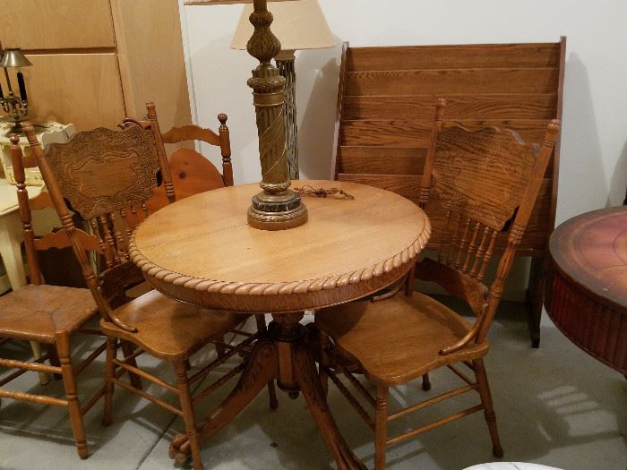 Oak table & two press-back chairs.  Behind it is a magazine rack that appears to have come from a school or library