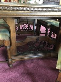 Antique table with wrought iron decor on bottom