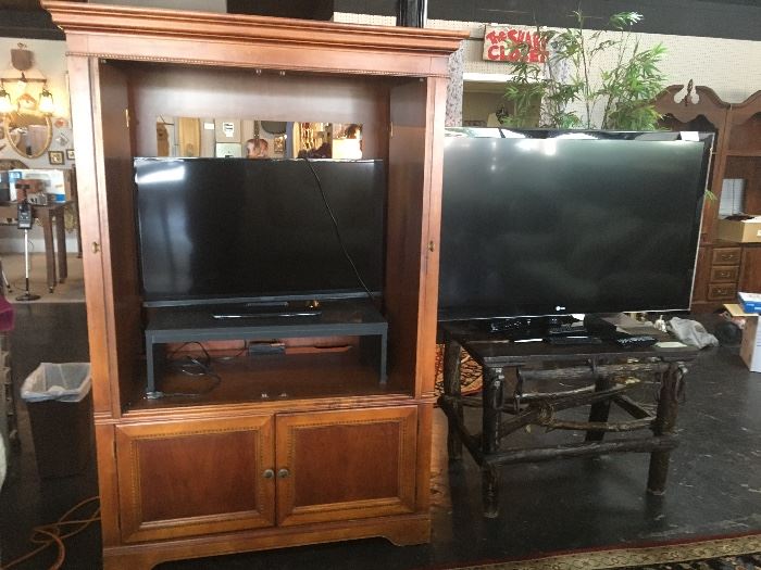 Cherry TV Cabinet with pull-out doors, 39" Insignia TV, and a 55" LG TV