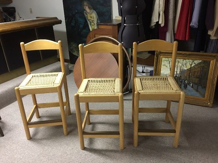 Three light wood and rope counter chairs.