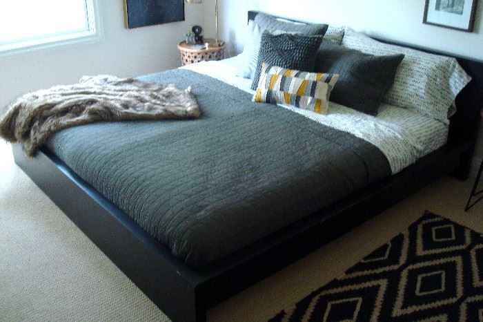King bed frame with pair twin mattresses and bedding.
