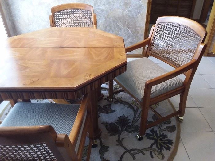 Octagon Dining room table with 4 cane back chairs on casters, newly upholstered!