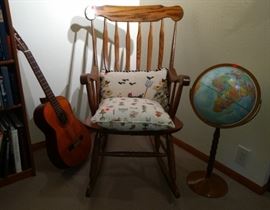Rocking chair, classical guitar, and 1970s globe.