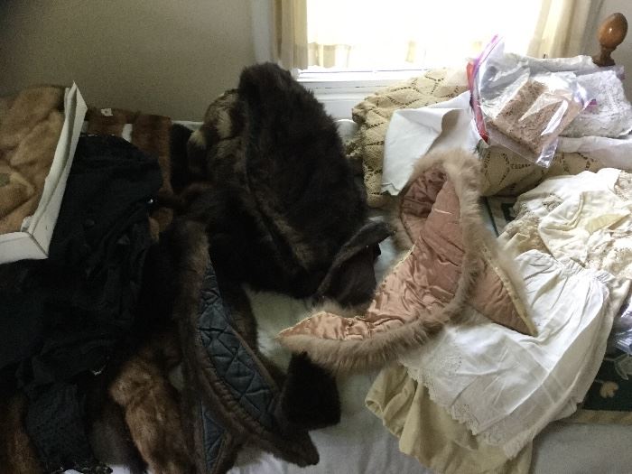 Fur stoles and vintage baby clothes and lace items.