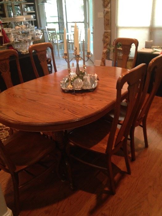 This extra large oval dining table has 6 chairs,  4 leaves, and pads. (There is a storage area under the table for the leaves- great feature.)