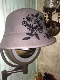 Gray and black hat atop a magnifying mirror
