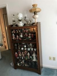 Vintage Santa’s , oil lamps and antique mission oak cabinet with2 glass panel door