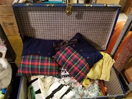 Vintage travel trunk filled with linens, curtains, pillows, etc