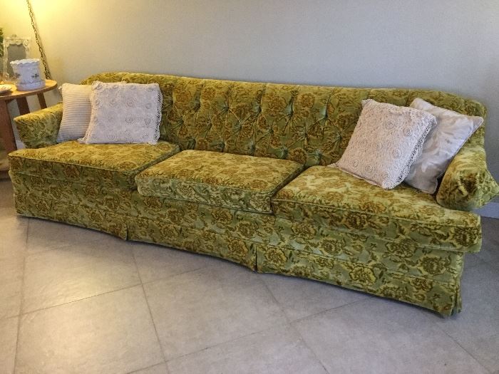 Long and low, sixties sofa of the green gold velvet kind