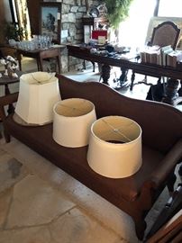 Low leather (I believe) wood antique sofa and lampshades.  Gateleg table and crystal, Small pedastle side table.  (Painting, dining room tables and chairs and display cabinet sold)