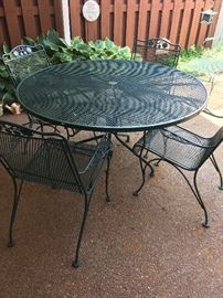 Round green iron table and 4 chairs, also have floral seat cushions
