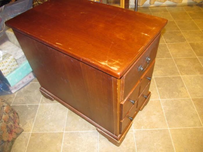 one of a pair of end tables; one side has a drawer over cabinet; the rear side has a pull-out magazine rack