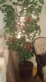 one of two faux trees with lights and birds