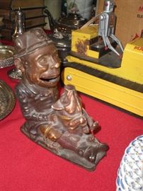 cast iron Leprechaun holding a pig mechanical bank