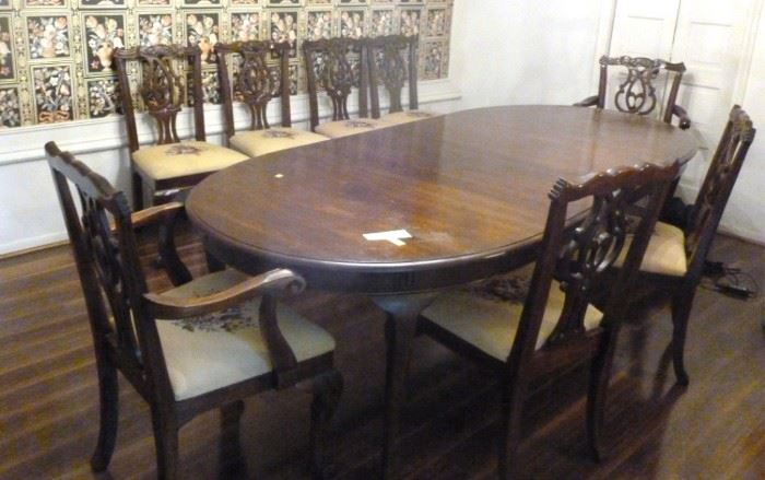 Solid wood dining table with 8 Chippendale style  needlepoint chairs and three leaves, 64" L  (without leaves) x 44" W, 30" H (leaves are 18"  L), Chair 24" W x 18" D, 38" H
