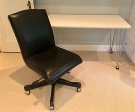 White desk, leather swivel office chair.