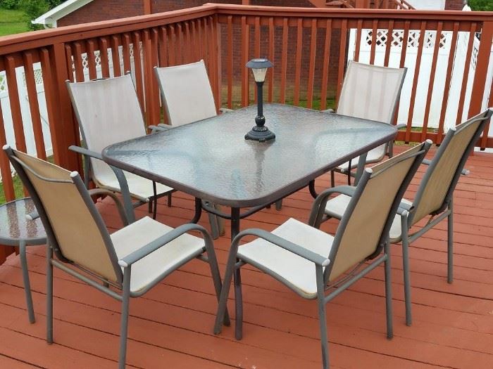 Glass top patio table, six chairs, and one small round glass top table