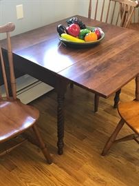 Drop Leaf Table with Four Chairs- Two with Arms . A warm brown finish