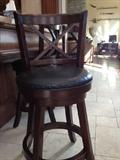 bar stools, walnut finish with black leather seats. There are three of them.