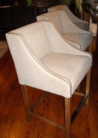 Three oversize upholstered bar stools.