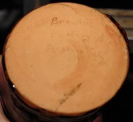Alkaline-Glazed Stoneware Face Jug, possibly Brown Pottery, Arden, NC, 20th century, semi-ovoid jug with applied clay face including bulging eye and an open mouth with porcelain teeth, the surface covered in a mottled brown alkaline glaze. 
