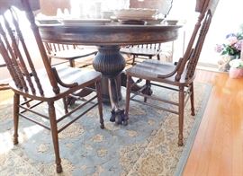 Beautiful antique oak table with paw feet.                           Nice gray-blue rug.