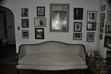 Sheridan style camel back sofa & autographed photographs of famous Black artists, musicians’ authors & athletes on wall.