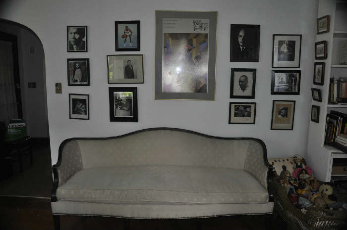 Sheridan style camel back sofa & autographed photographs of famous Black artists, musicians’ authors & athletes on wall.