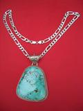 Large Navajo turquoise pendant in sterling bezel with sterling chain. Stone measures 2 1/4" by 2 5/8" and is 3/8" thick. No cracks, chips or rough surfaces. Believe that it came from either the Crow Springs or Pilot Mountain mines. Total weight of necklace and pendant is 6.64 ounces.
See our website for additional photos