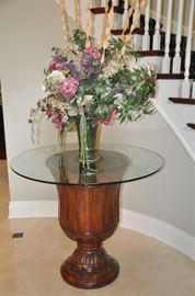 Large 42" glass top with carved mahogany and black granite base table. 36"h. Shown with large flower arrangement. (centerpiece sold)