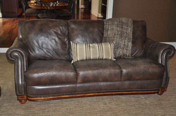 82" distressed brown leather sofa with brass nailhead design  36"h x 36"d 